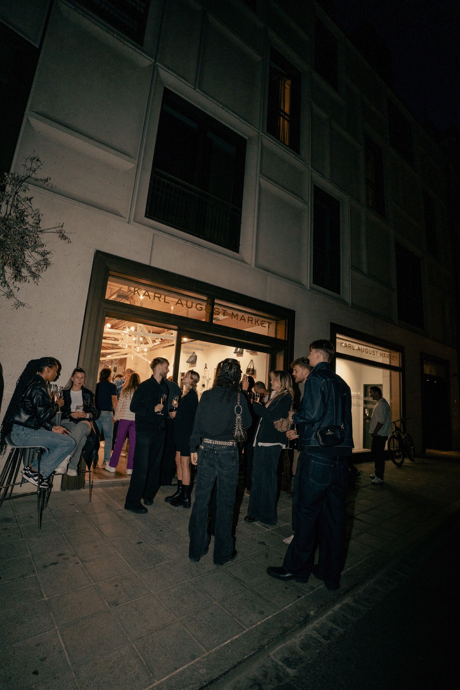 Gäste abends vor dem beleuchteten Store bei der Artable x MACH1 Pre-Party