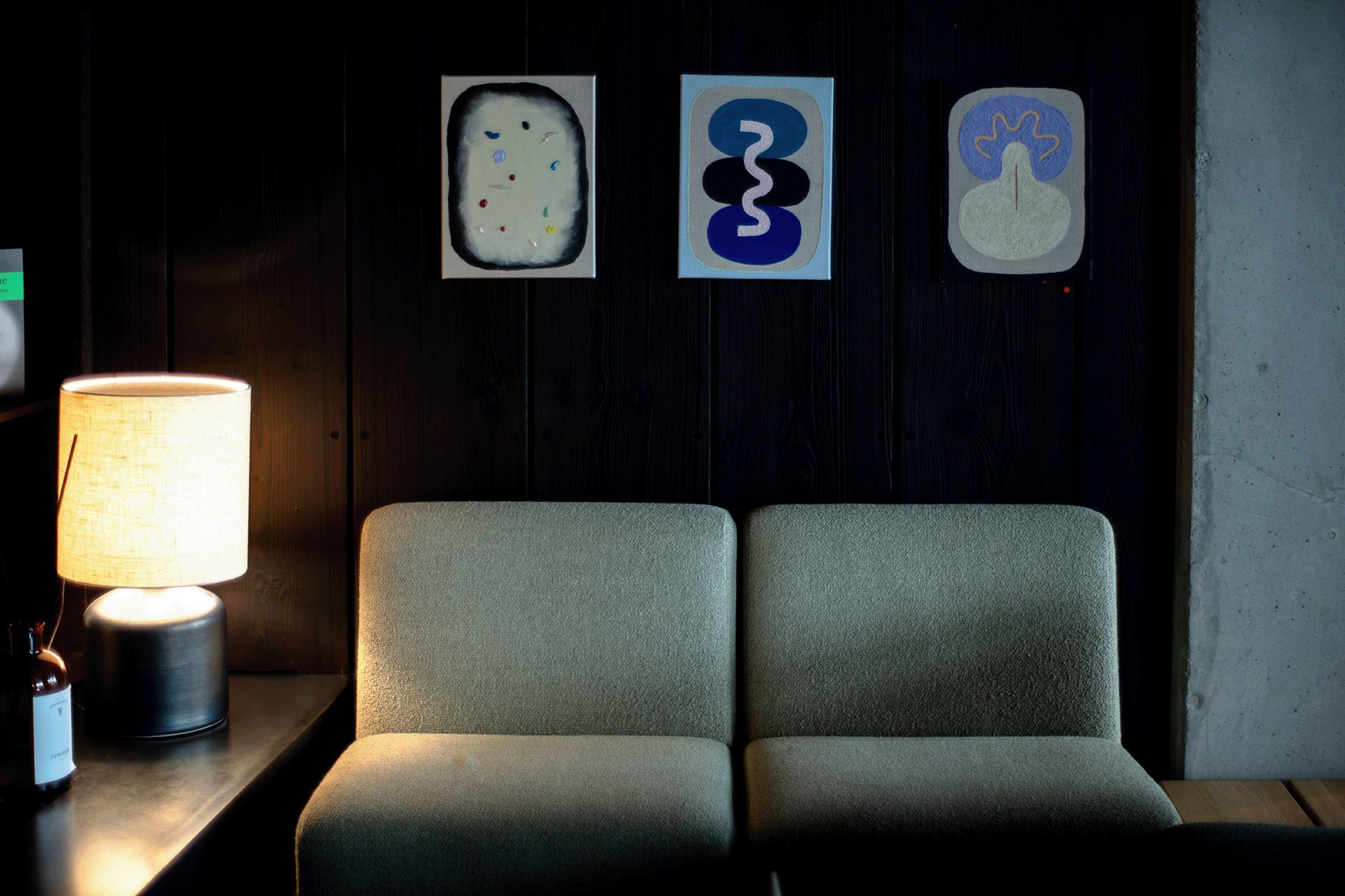 Loungebereich mit Tischlampe und Bildern in warmem Licht
